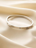 Silver bracelet with small stones on a beige fabric background