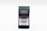 Silver ring in a green box on a white background