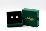 Gold flower earrings in a green Zelenska Jewellery box on a white background