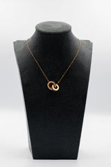 Gold necklace on a black bust against a white background