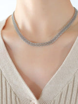 Silver chain necklace on a mannequin with a plain background
