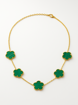 Gold necklace with green clover-shaped pendants on a white background