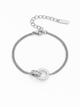 Silver bracelet with chain and circular design on a white background