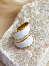 Gold and white ring on a textured stone surface